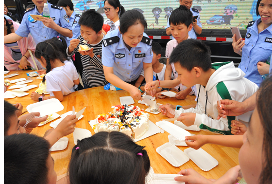 图为民警在给儿童分发生日蛋羹。.JPG