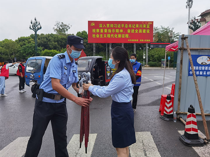 2高县农商银行党委为街道卡口交警送去雨伞.jpg