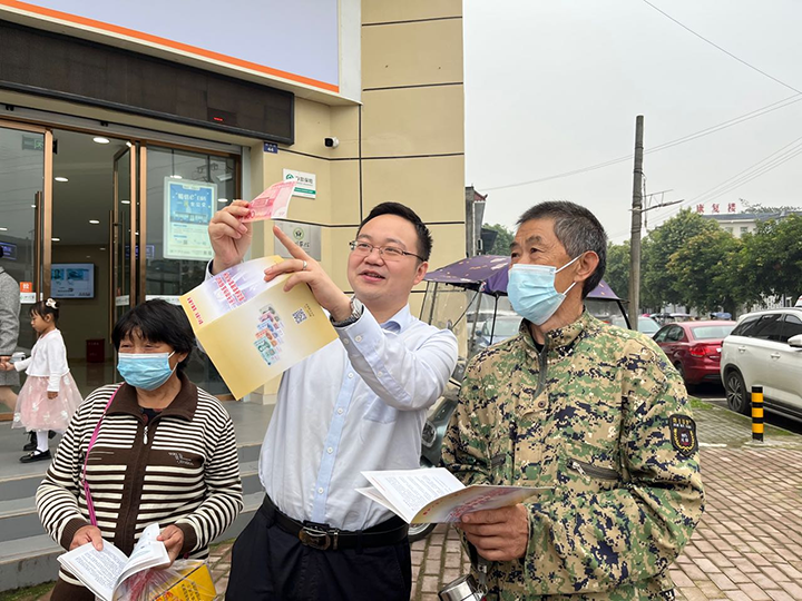 6为客户经理正在为群众介绍人民币防伪特征.png