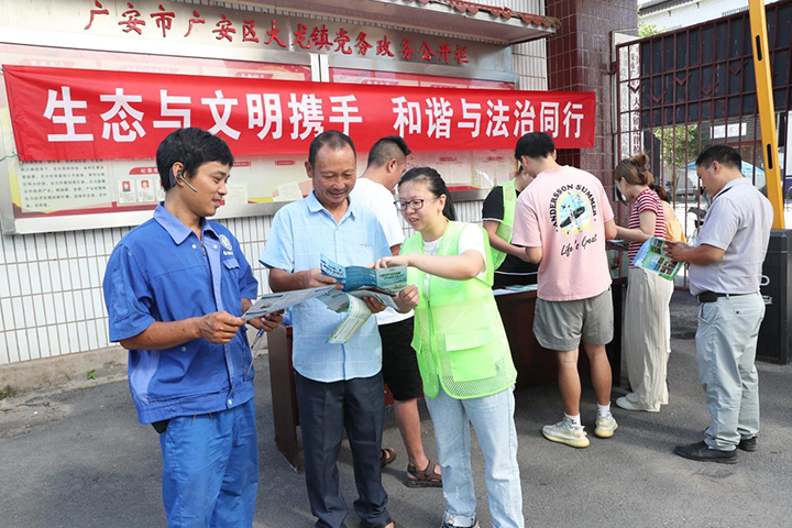 图片1 广安区生态环境局环保志愿者在向大龙镇群众宣传水环境保护相关法律法规.png
