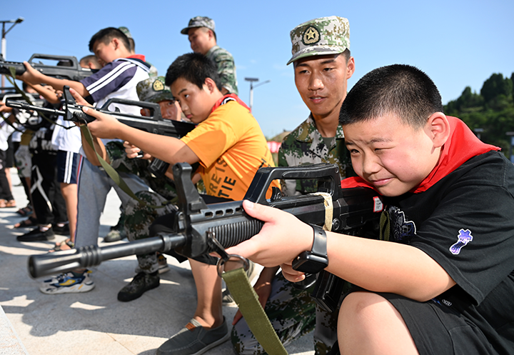 图3  孩子们正在体验民兵武器装备.png