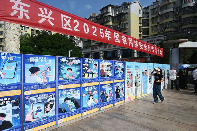 图4  2025年9月15日，市民在四川省内江市东兴区东兴街道平桥社区观看防范电信诈骗等方面的宣传展板。.jpg