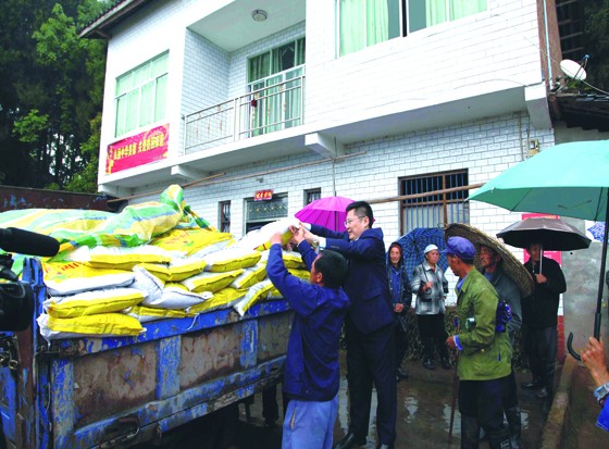 冒雨从货车上卸载化肥.jpg