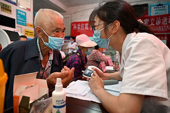 3)6月9日，在内江市东兴区高梁中心卫生院，医护人员为癌症患者测血糖.jpg