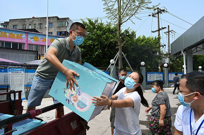 1在内江市东兴区椑木中心卫生院，医护人员头顶烈日搬运清凉物品.jpg