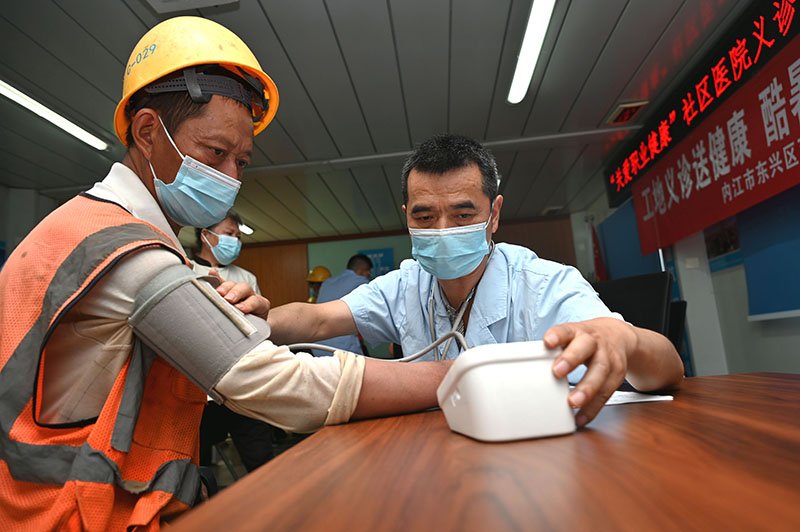 2东兴区西林社区卫生服务中心医护人员在某项目工地上为农民工量血压.jpg