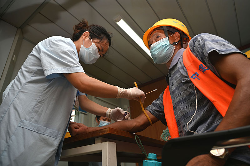 4东兴区西林社区卫生服务中心医护人员在某项目工地上为农民工做血液检查.jpg