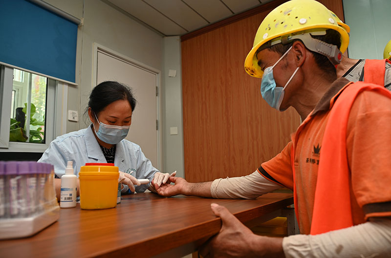 3东兴区西林社区卫生服务中心医护人员在某项目工地上为农民工测血糖.jpg