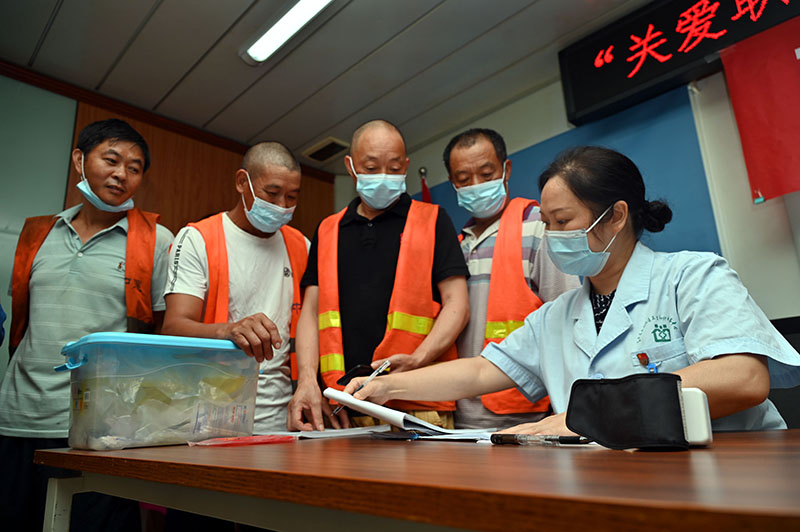 5东兴区西林社区卫生服务中心医护人员在某项目工地上为农民工宣传防艾等健康知识.jpg