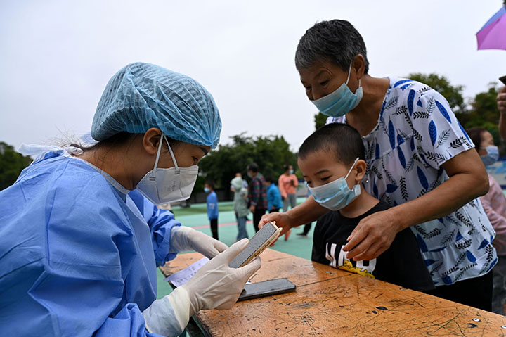 2医护人员和志愿者正在帮助师生扫健康码登记信息.jpg