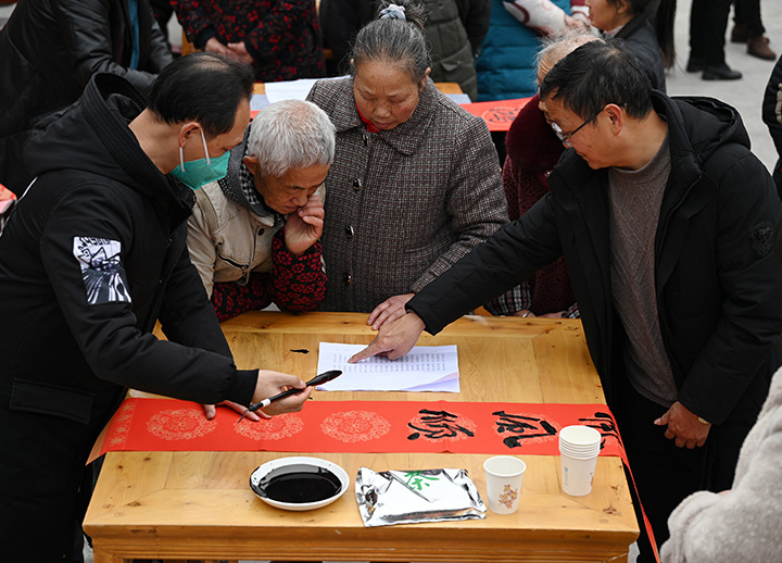 2)在内江市东兴区椑木镇沙石村，书画师正为群众书写春联.jpg