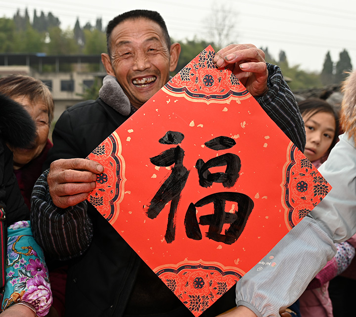 5)在内江市东兴区椑木镇沙石村，村民在展示刚刚领到的“福”字.jpg