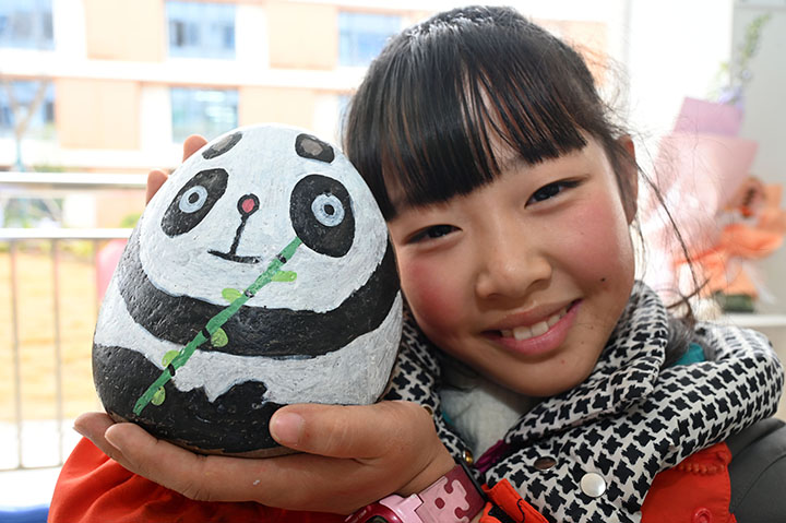 图6  鹅卵石画兴趣班的学生正在展示自己的作品.jpg