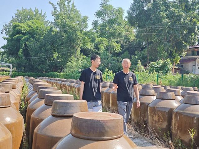图3  杨宗明与杨济先察看晒场.jpg
