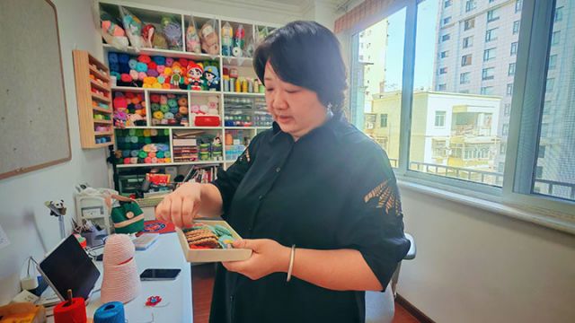 图3  唐文苹展示钩编作品。闫凯 摄.jpg
