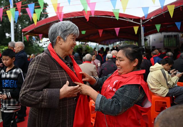 图1  10月25日，四川省内江市东兴区永福镇鲤鱼塘村，志愿者为村里的老人系上暖心的红围巾。.jpg