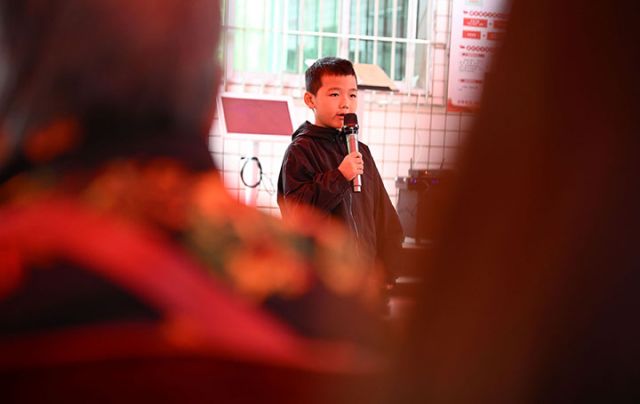 图4  一名儿童正在为老人表演节目，以此促进代际情感联结，丰富老人精神世界。.jpg